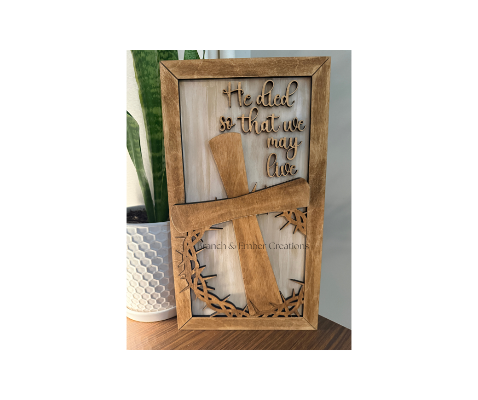 Wooden sign “He died so that we may live”