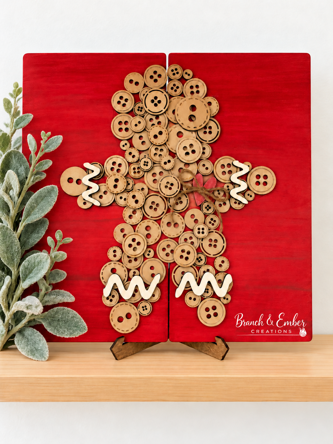 Button Gingerbread Man shelf sitter on red wood panels with cream icing accents and a rustic bow.