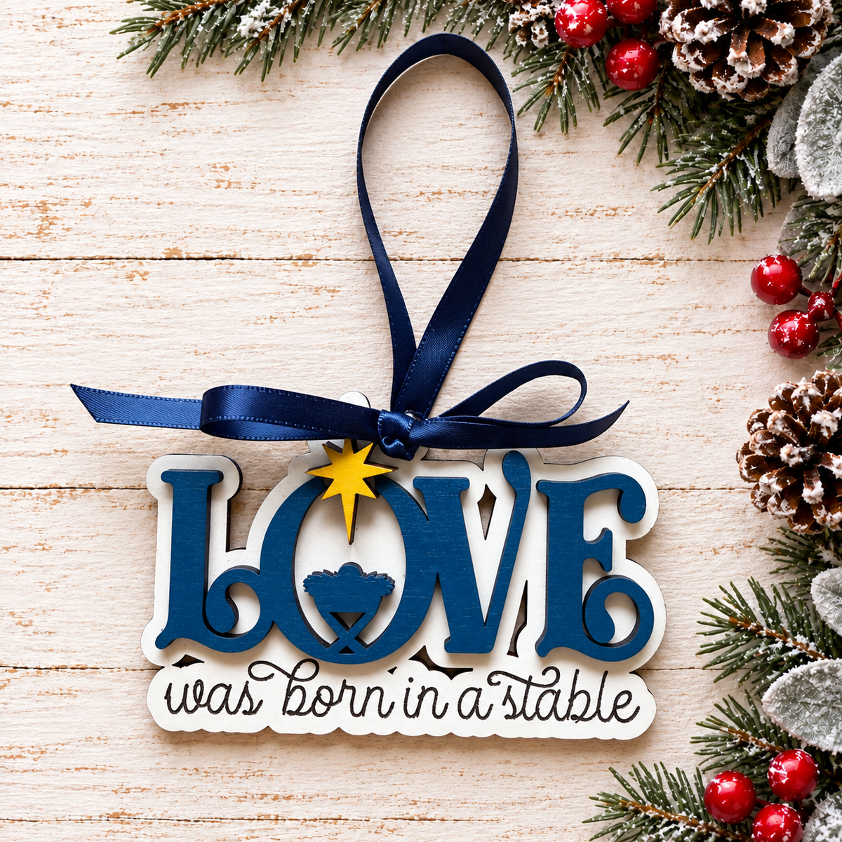Blue and white Love Was Born in a Stable ornament with navy bow